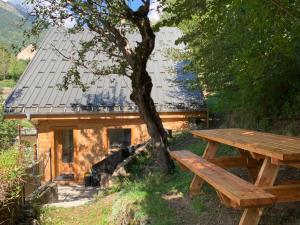einen hölzernen Picknicktisch neben einem Baum in der Unterkunft Chalet La Felize in 