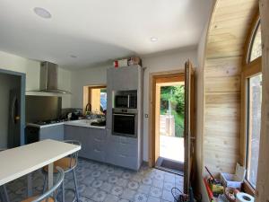 a kitchen with stainless steel appliances and a table at Chalet La Felize in Oz