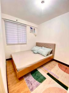 - une petite chambre avec un lit et une fenêtre dans l'établissement Minimalist 1-bedroom condo unit CASA TIMMY, à Davao