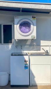 una lavadora y secadora en una cocina con fregadero en Cosy guesthouse with private garden, en Padstow