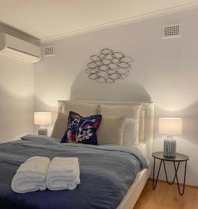 een slaapkamer met een bed met 2 kussens en 2 lampen bij Cosy guesthouse with private garden in Padstow