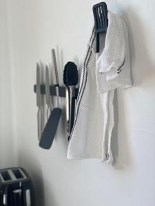 a white towel hanging on a wall with kitchen utensils at Cosy guesthouse with private garden in Padstow