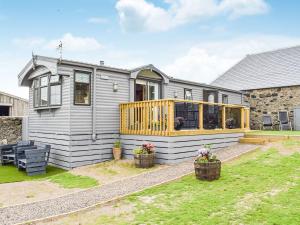 a tiny house with a deck on a yard at Secret Garden in Smailholm