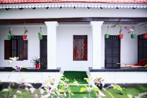 a white house with black doors and windows at Bobbys Corner in Alleppey