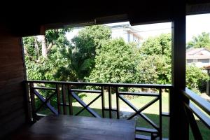 uma vista para um alpendre com um banco e árvores em Song Lao Guesthouse em Thakhek