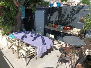 拉西約塔的住宿－La Casa De La Ciotat，庭院内一张桌子和椅子,配有紫色的桌布