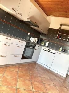 a kitchen with white appliances and a tile floor at L’Alsacien Cosy : Duplex - Netflix - Wifi/Fibre in Mulhouse