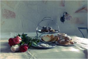 uma mesa com dois pratos de comida numa mesa com rosas em Lazzarella B&B em Polignano a Mare