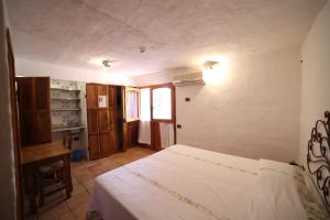 a bedroom with a bed and a desk and a window at Residenza Capriccioli in Porto Cervo