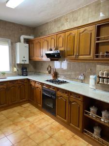 a kitchen with wooden cabinets and a stove top oven at Barrero 47 in Igualeja