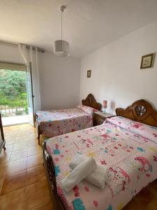 a bedroom with three beds and a window at Barrero 47 in Igualeja +4 photos