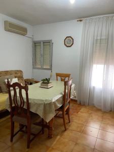 une salle à manger avec une table, des chaises et une horloge dans l'établissement Barrero 47, à Igualeja