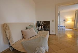 uma sala de estar com um sofá e um quarto em Paterre Wohnung in der Rosa Villa em Selb