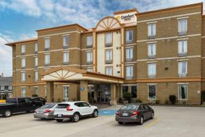 two cars parked in a parking lot in front of a hotel at Comfort Hotel Bayer's Lake in Halifax