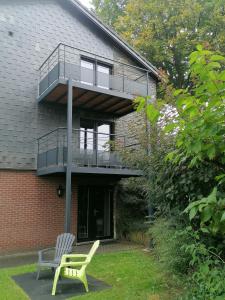 uma casa com varanda e um banco no quintal em L'Horizon Studios & Apparts em Malmedy
