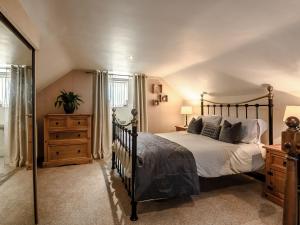 a bedroom with a bed and a dresser and a mirror at Nightingale Lodge in Ropsley