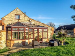 una casa con un salón acristalado en el patio en Nightingale Lodge, en Ropsley