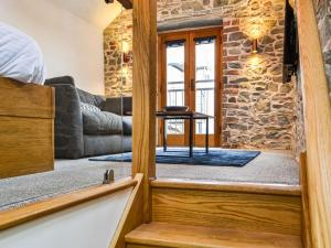 a door leading into a living room with a stone wall at The Old Stable in Keswick