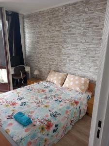 a bedroom with a bed and a brick wall at Chambre privée, proche Aéroport PARIS-Orly in Athis-Mons
