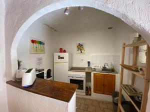 a kitchen with an archway with a white refrigerator at Charmante petite maison de village au centre in Correns