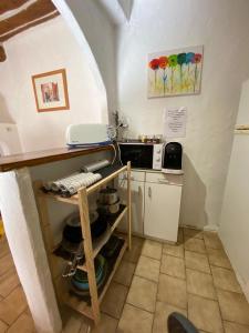 a small kitchen with a counter and a microwave at Charmante petite maison de village au centre in Correns