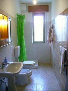 a bathroom with a sink and a toilet and a window at Casa Gelferraro in Calatafimi