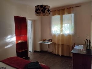 een kamer met een tafel en een raam met een bureau bij Chambre privée avec parking in Nîmes
