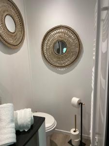 ein Bad mit einem WC und einem Wandspiegel in der Unterkunft la chambre de lola in Waterloo