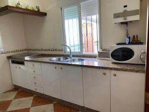a kitchen with a sink and a microwave at Casa Medina in Algodonales