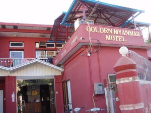 a red building with a sign for the golden my animal motel at Golden Myanmar Guest House in Bagan