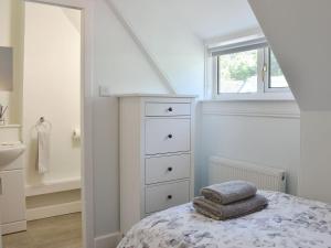 a bedroom with a bed with a dresser and a window at 1 Hamilton Terrace in Lamlash