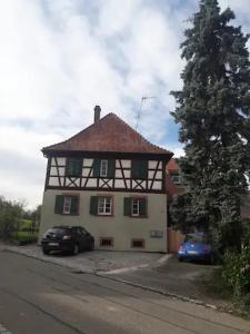 een wit en zwart huis met auto's geparkeerd voor het bij Trad. Blackforest House in Ettenheim