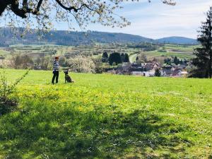 een persoon in een veld met een hond bij Trad. Blackforest House in Ettenheim