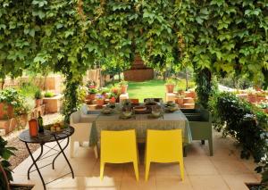 una mesa y sillas sentadas bajo un gran árbol en Casa Los Bancales, en Candeleda