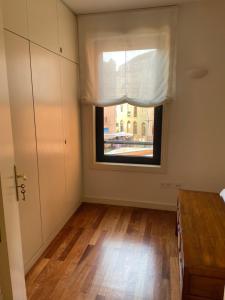 an empty room with a window and a wooden floor at Apartamento Mimi in Figueira da Foz