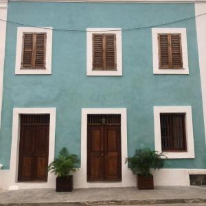 un bâtiment bleu avec deux portes et deux fenêtres dans l'établissement Casa Fabula, à Île de Mozambique