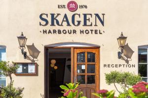 un letrero para un hotel Harcourt al lado de un edificio en Skagen Harbour Hotel, en Skagen