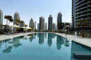 a large swimming pool in the middle of a city at Dubai Marina, Two bedrooms apartment with full Marina View in Dubai