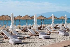 un grupo de tumbonas y sombrillas en una playa en Hotel Giannoulis, en Paralia Katerinis