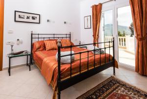 a bedroom with a bed and a balcony at Villa Gabriella Lefkada in Vafkeri