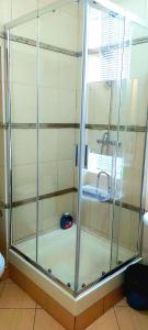 y baño con ducha de cristal y lavabo. en DBS Hotel, en Bălţi