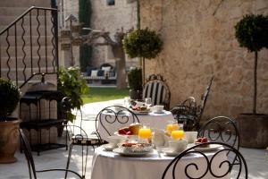 een tafel met eten en drinken op een patio bij Hôtel Gounod in Saint-Rémy-de-Provence