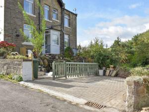 a house with a wooden fence in front of it at Slant End Cottage in Golcar