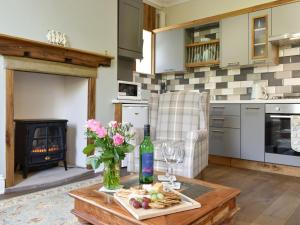 a kitchen with a table with a vase of flowers at Slant End Cottage in Golcar