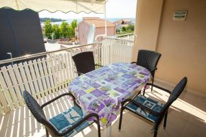 a balcony with a table and chairs on a balcony at Apartments & Rooms Peranic in Novalja
