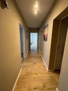 a hallway of an empty room with a wooden floor at Linden Monteur Apartment in Rodenbach