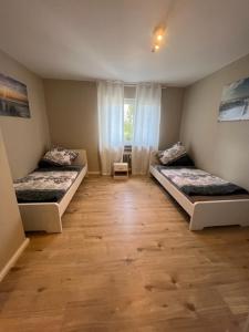 a room with two beds and a wooden floor at Linden Monteur Apartment in Rodenbach