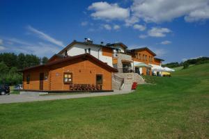 a large house on a hill with a green field at Ośrodek Wypoczynkowy Jacnia in Jacnia