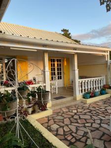 una casa con un portico con piante in vaso di Les Capucines a Saint-Pierre