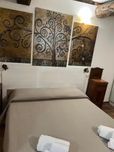 a bedroom with a bed with three paintings on the wall at Appartamento Centro Storico Fondi in Fondi +8 photos